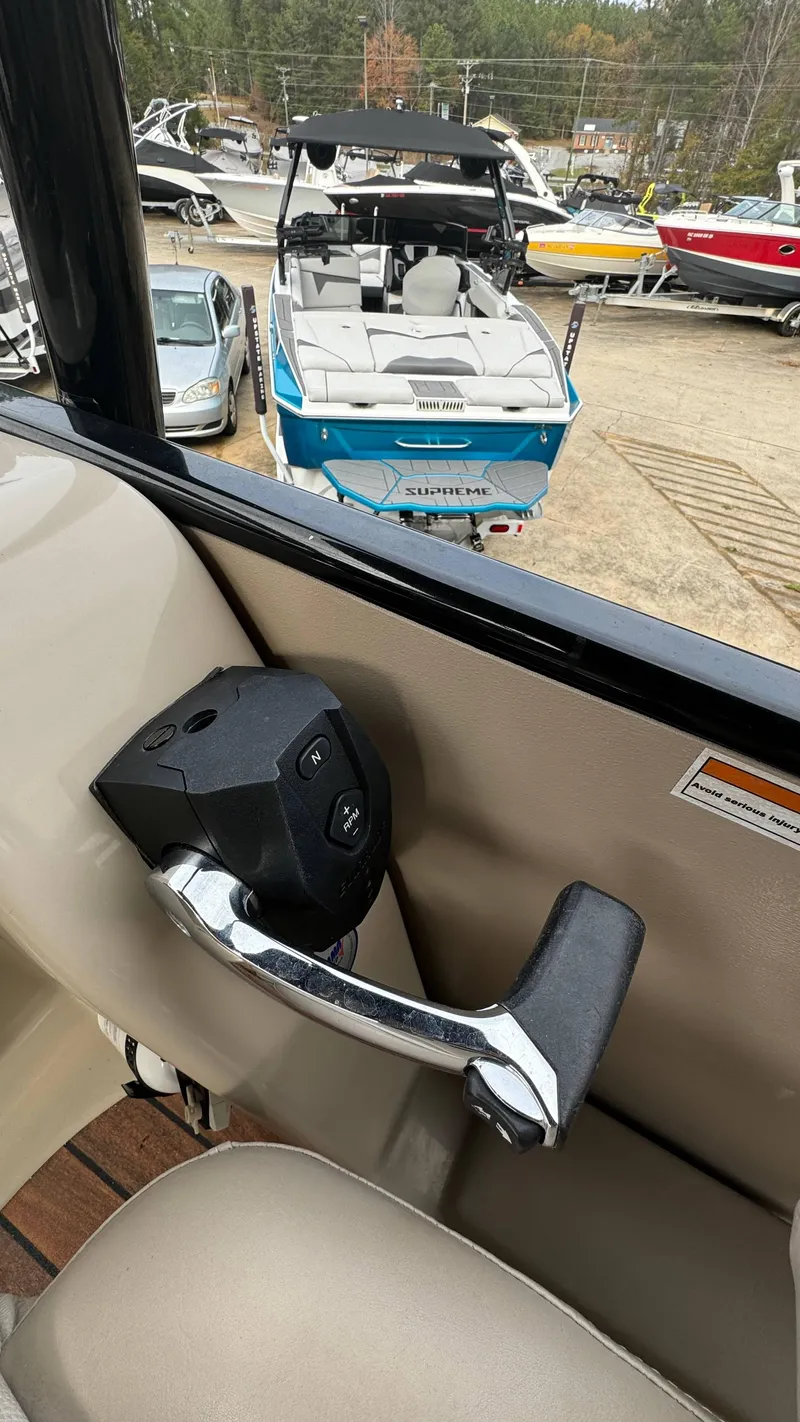 Slide: The Image of Interior view of 2015 Avalon 2785 Paradise boat with control lever, overlooking docked boats. - 19