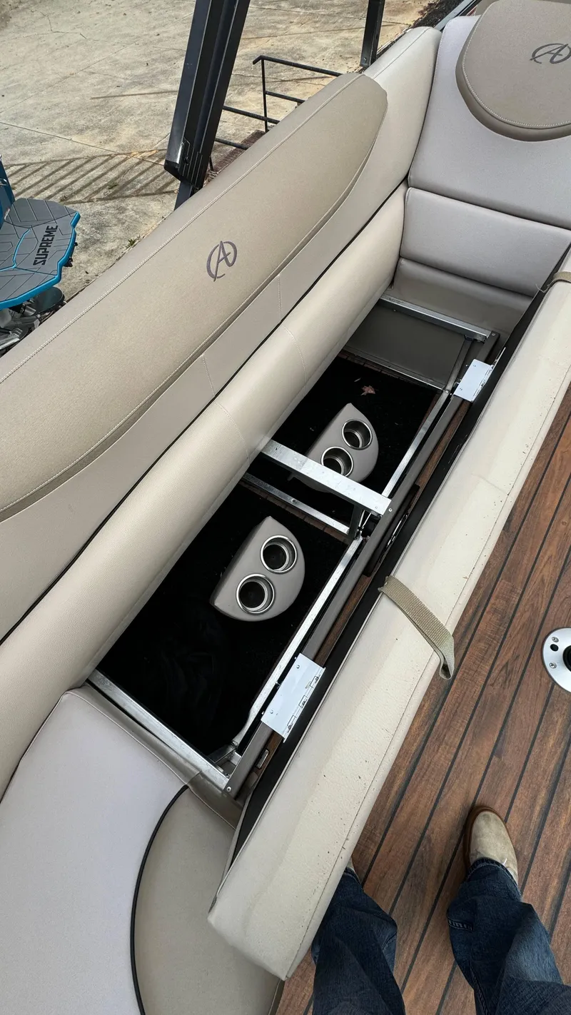 Slide: The Image of 2015 Avalon 2785 Paradise boat seat storage with cup holders on wooden deck. - 21