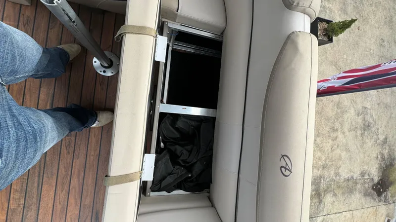 Slide: The Image of 2015 Avalon 2785 Paradise boat interior with open storage compartment and wooden flooring. - 28