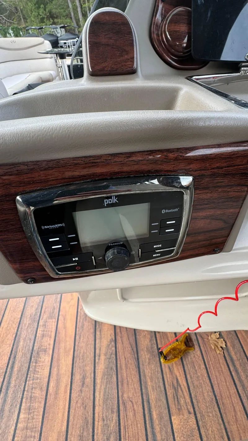 Slide: The Image of Avalon 2785 Paradise 2015 boat dashboard with Polk audio system and wood accents. - 29