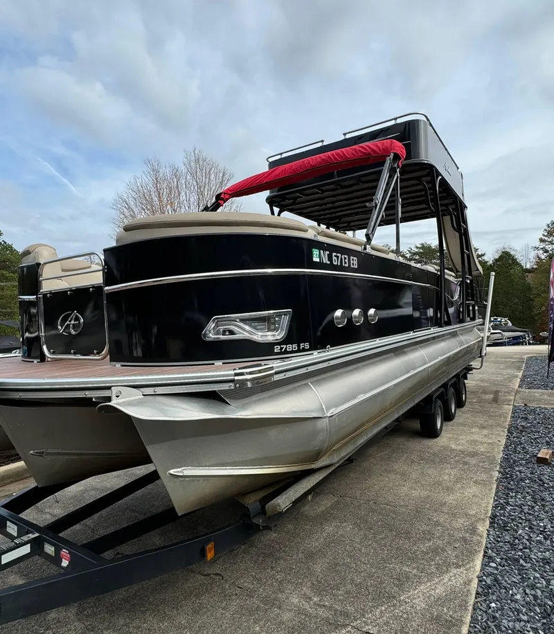 Slide: The Image of 2015 Avalon 2785 Paradise pontoon boat on trailer, black exterior, red canopy. - 3