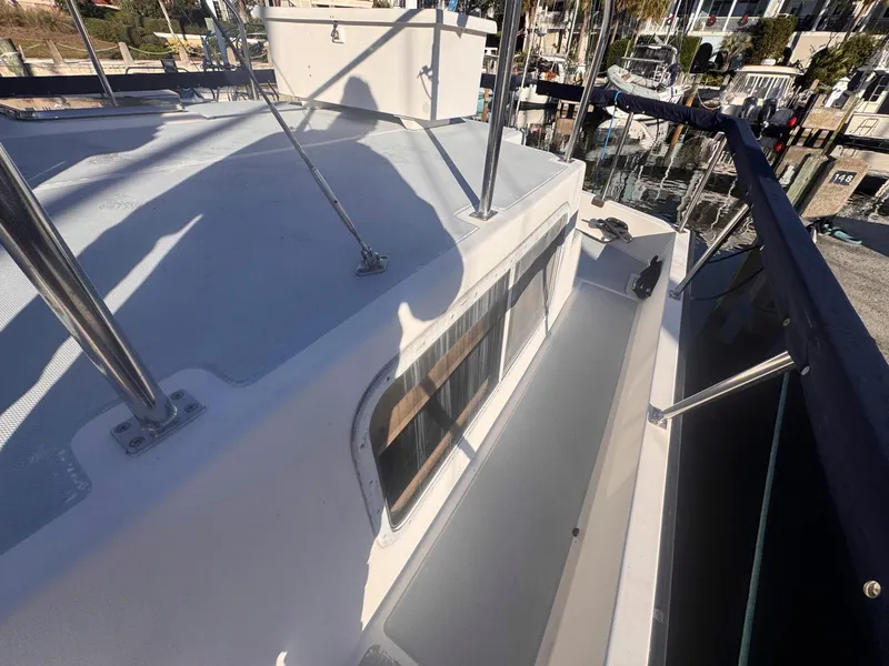 Slide: The Image of 1999 Monk 36 Trawler deck view with railings and marina background. - 15
