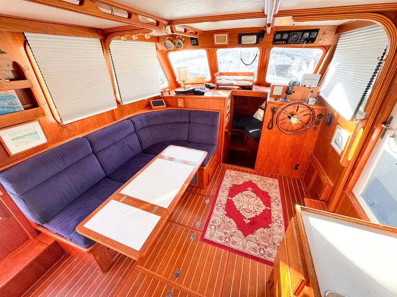 Slide: The Image of Interior of 1999 Monk 36 Trawler with wood finish and blue seating. - 17