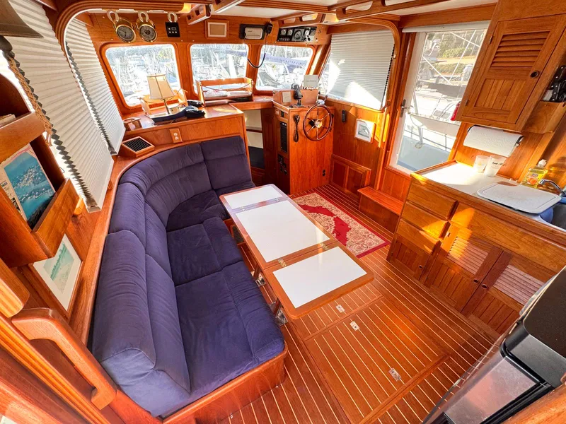 Slide: The Image of Interior of 1999 Monk 36 Trawler with wooden finish and blue seating. - 21