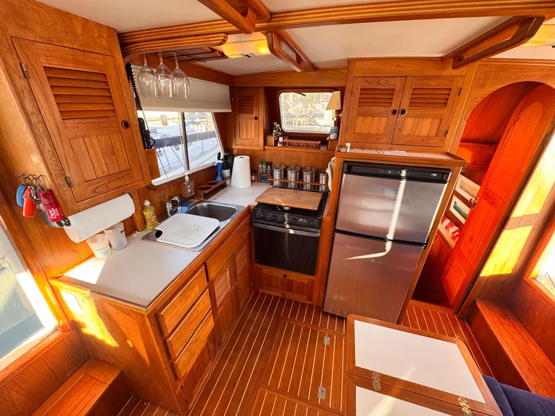 Slide: The Image of Warm wood interior of 1999 Monk 36 Trawler kitchen with modern appliances. - 22