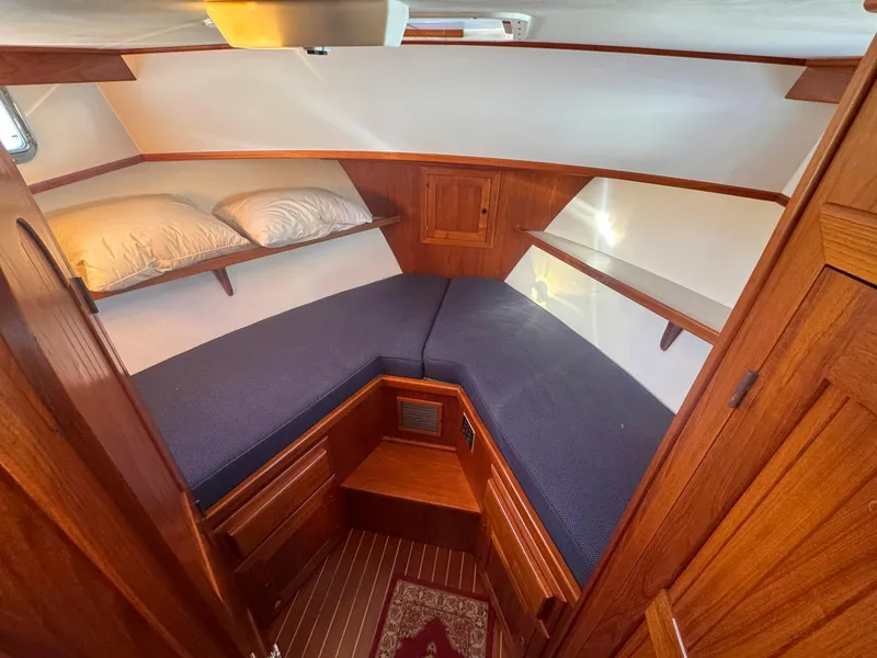 Slide: The Image of Cozy cabin interior of 1999 Monk 36 Trawler with wooden finish and blue bedding. - 31