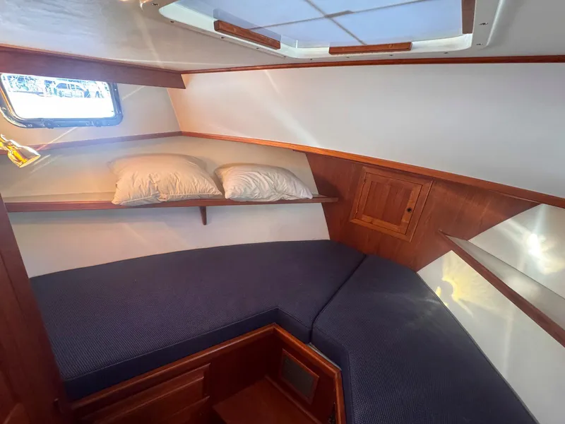Slide: The Image of Cozy cabin interior of 1999 Monk 36 Trawler with blue cushions and wooden accents. - 32