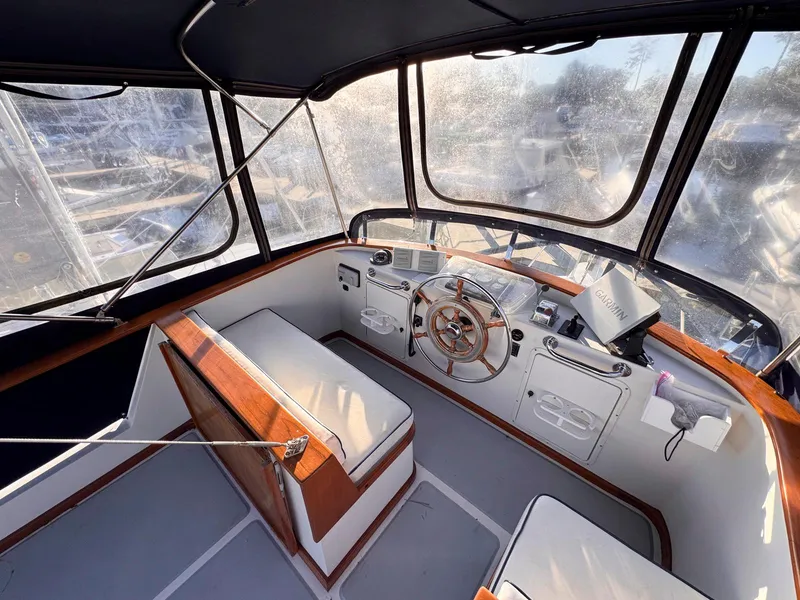 Slide: The Image of 1999 Monk 36 Trawler helm with wooden accents and cushioned seating. - 4