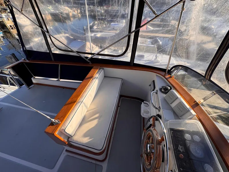 Slide: The Image of 1999 Monk 36 Trawler helm with cushioned seating and clear windows. - 7