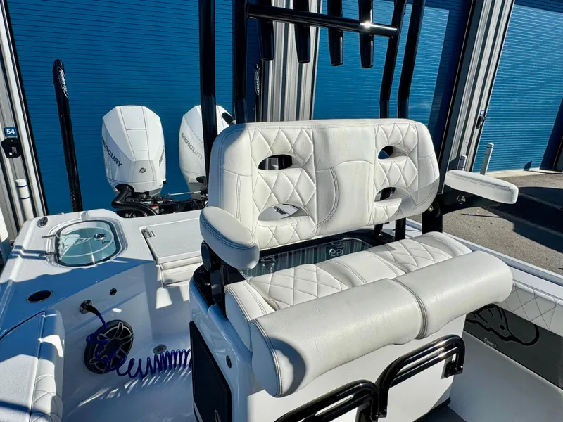 Slide: The Image of 2024 Blazer 2700 HYBRID BAY boat interior with white seating and dual engines. - 16
