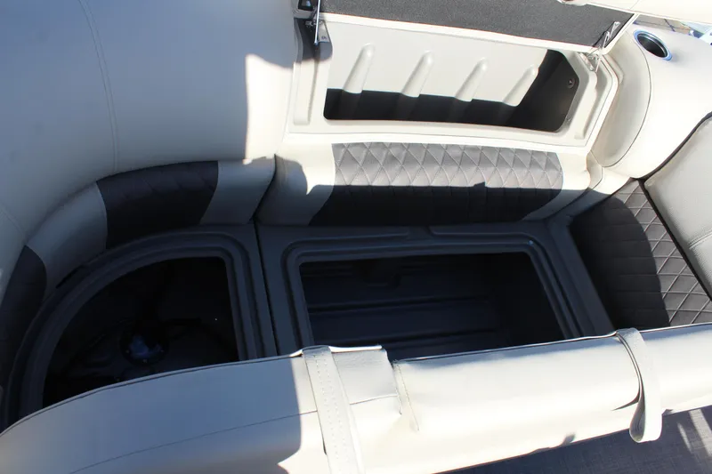 Slide: The Image of 2025 Sun Tracker Party Barge 22 DLX interior storage compartment with cushioned seating. - 18