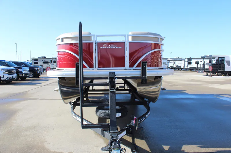 Slide: The Image of 2025 Sun Tracker Party Barge 22 DLX pontoon boat on trailer in parking lot. - 2