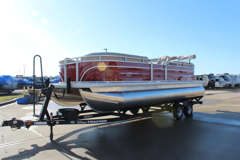 Slide: The Image of 2025 Sun Tracker Party Barge 22 DLX pontoon boat on trailer, sunny day. - 3