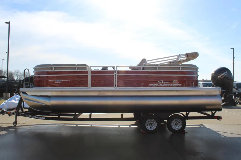 Slide: The Image of 2025 Sun Tracker Party Barge 22 DLX pontoon boat on trailer, side view. - 4