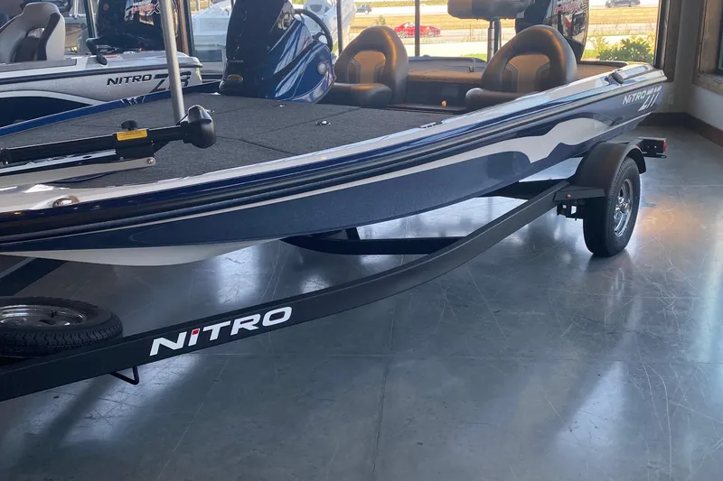 The Image of 2025 Nitro Z17 boat on display in a showroom, featuring sleek design and trailer. - 0