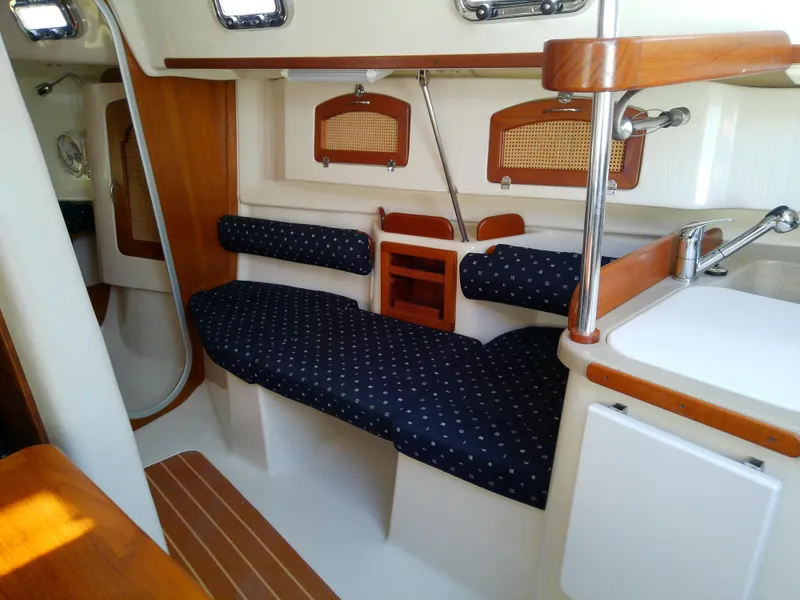 Slide: The Image of 2017 Hake Seaward 32RK sailboat interior with blue cushioned seating and wooden accents. - 48