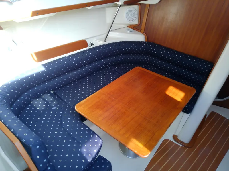 Slide: The Image of 2017 Hake Seaward 32RK yacht interior with blue cushioned seating and wooden table. - 49