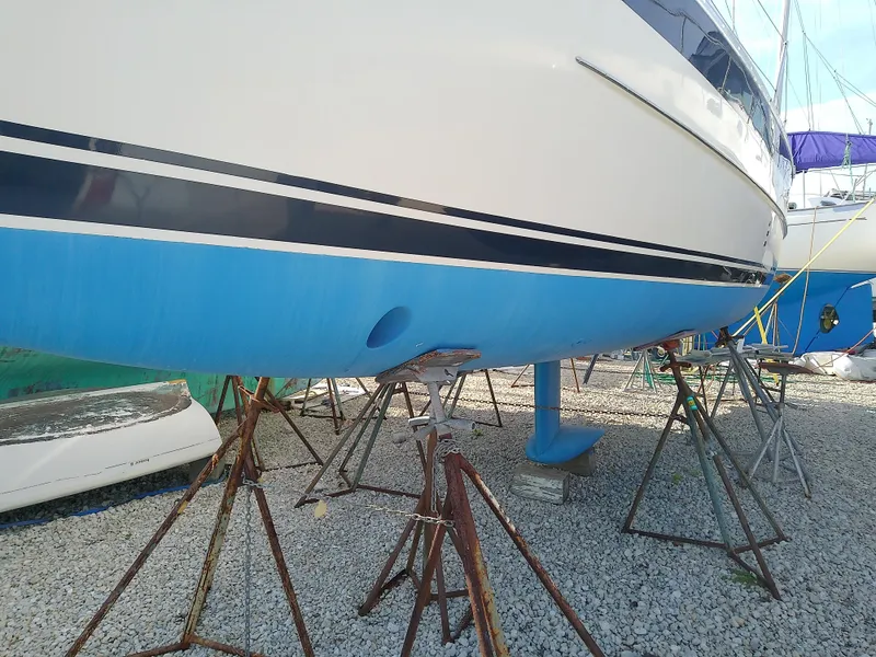 Slide: The Image of 2017 Hake Seaward 32RK sailboat on stands, blue hull, gravel ground. - 5