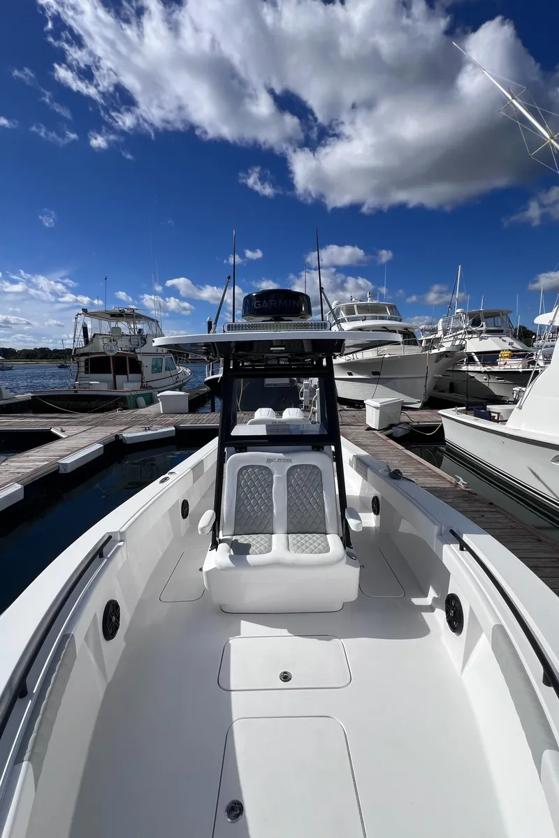 Slide: The Image of Reef Runner 280 boat docked at marina under blue sky, 2025 model. - 12
