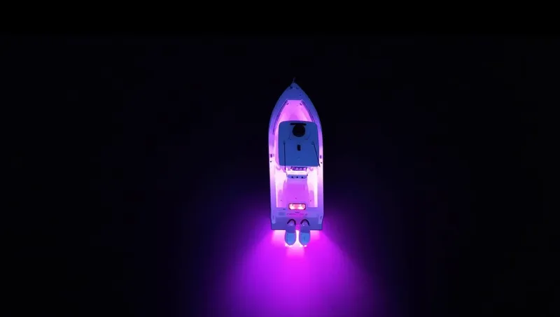 Slide: The Image of Aerial view of 2025 Reef Runner 280 boat with vibrant purple lights on water. - 13