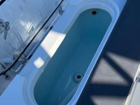 Slide: The Image of 2024 Sea Pro 240DLX boat livewell with open lid, showcasing interior. - 13