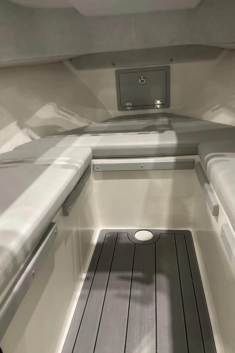 Slide: The Image of Captain's chair in 2025 Defiance Admiral 250 EX boat, featuring gray upholstery and control panel. - 12