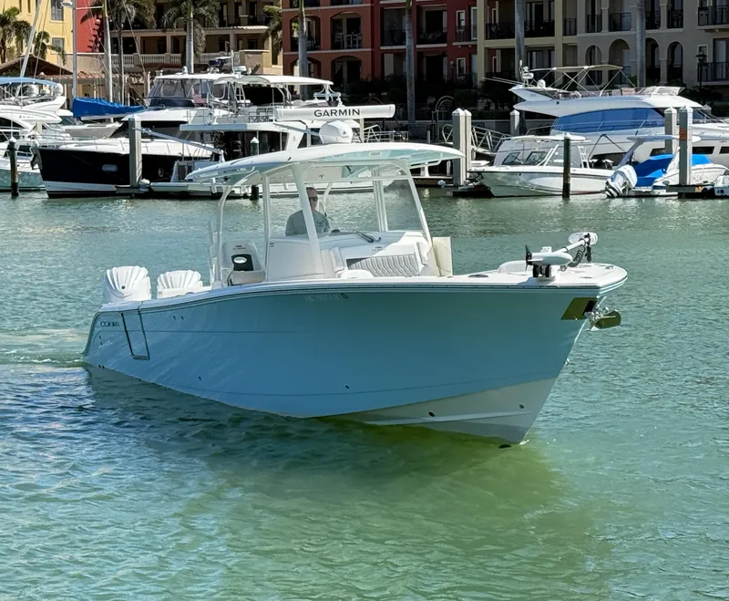 Slide: The Image of 2023 Cobia 350 Center Console boat in a marina, surrounded by other vessels. - 1