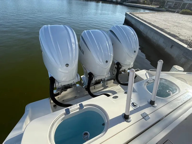 Slide: The Image of 2023 Cobia 350 Center Console with triple outboard engines docked by the water. - 10