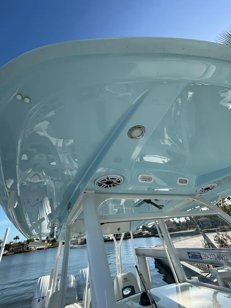 Slide: The Image of 2023 Cobia 350 Center Console boat, sleek design, blue hull, sunny day on the water. - 11