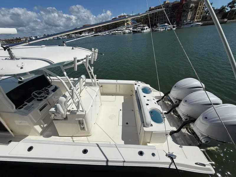 Slide: The Image of 2023 Cobia 350 Center Console boat with triple engines docked in a marina. - 12