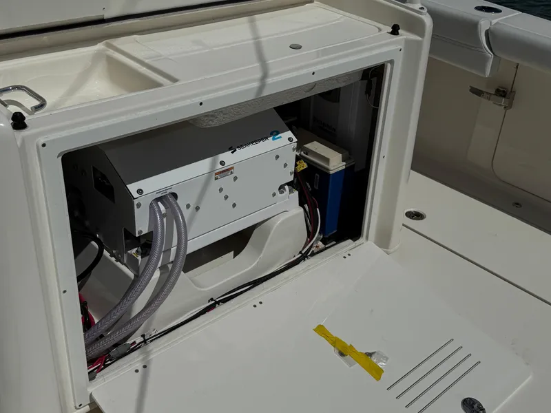 Slide: The Image of 2023 Cobia 350 Center Console boat's open compartment showing internal equipment and wiring. - 14