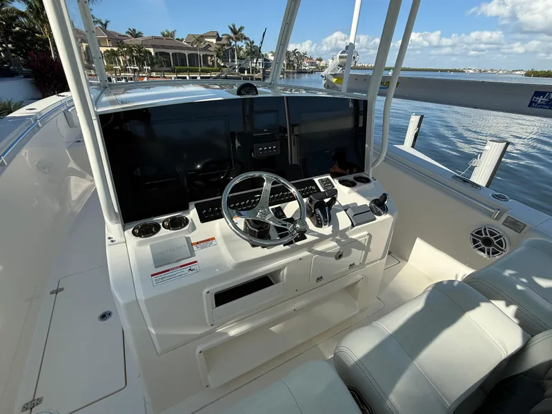 Slide: The Image of 2023 Cobia 350 Center Console boat helm with modern controls and waterfront view. - 17