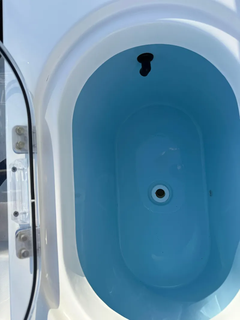 Slide: The Image of 2023 Cobia 350 Center Console livewell with blue interior. - 25
