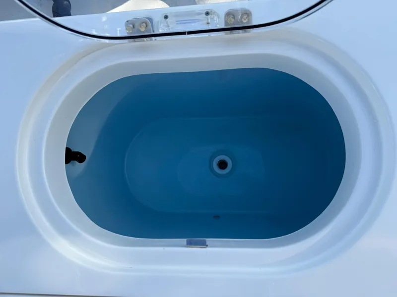 Slide: The Image of 2023 Cobia 350 Center Console livewell, open view, blue interior. - 26