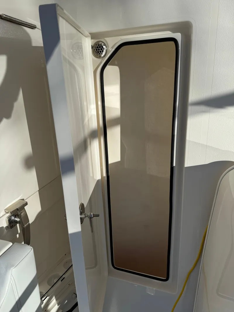 Slide: The Image of 2023 Cobia 350 Center Console storage compartment with open door. - 29