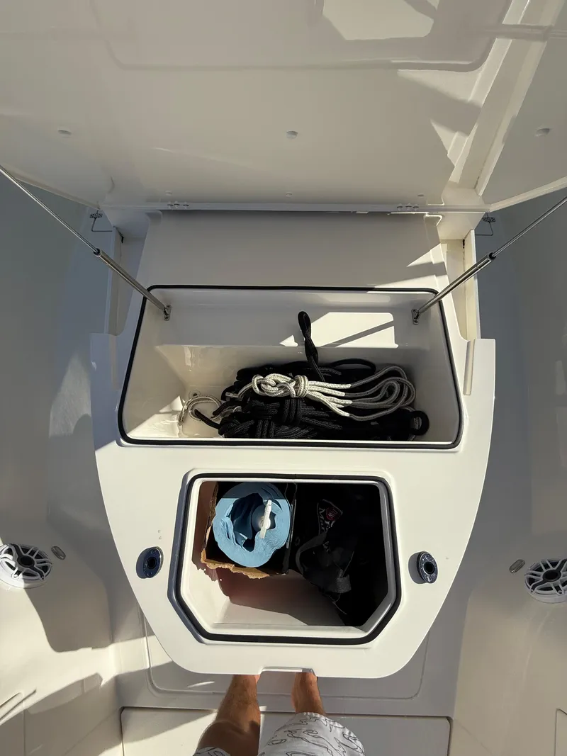 Slide: The Image of 2023 Cobia 350 Center Console storage compartment with ropes and gear. - 33