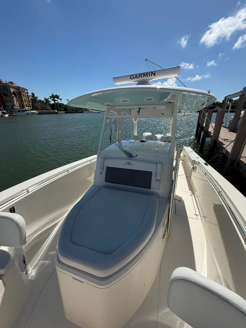 Slide: The Image of 2023 Cobia 350 Center Console boat docked by waterfront under clear blue sky. - 42