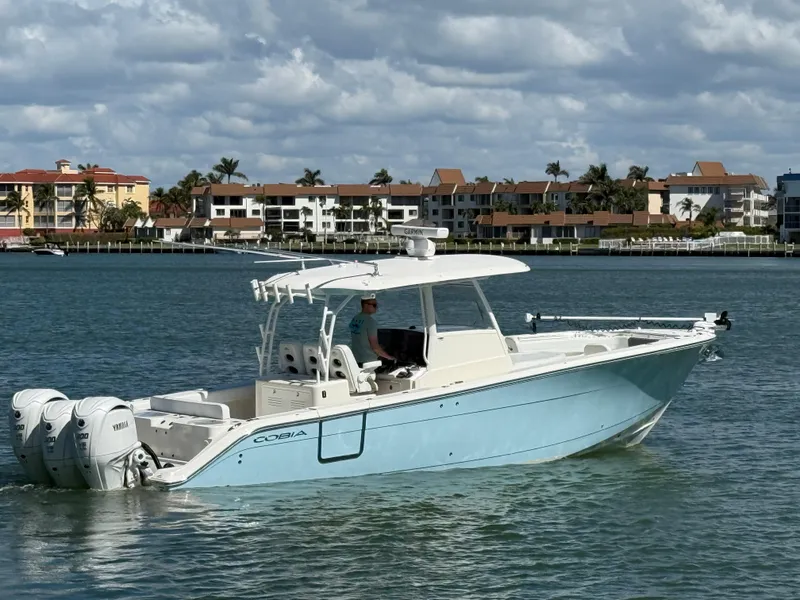 Slide: The Image of 2023 Cobia 350 Center Console boat on water with coastal buildings in background. - 7