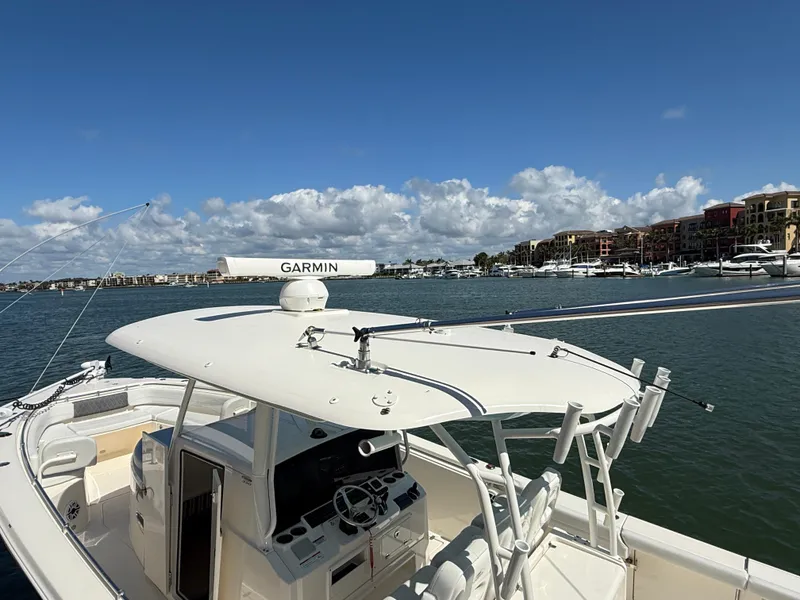 Slide: The Image of 2023 Cobia 350 Center Console boat on water with Garmin equipment, scenic marina backdrop. - 9