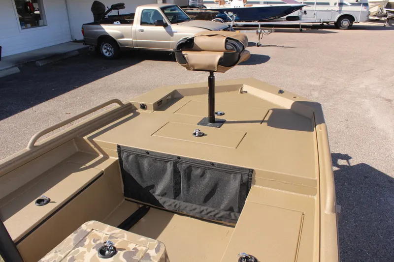 Slide: The Image of 2025 Excel 1860 F4 Shallow Water boat, tan deck, camo seat, parked outdoors. - 14