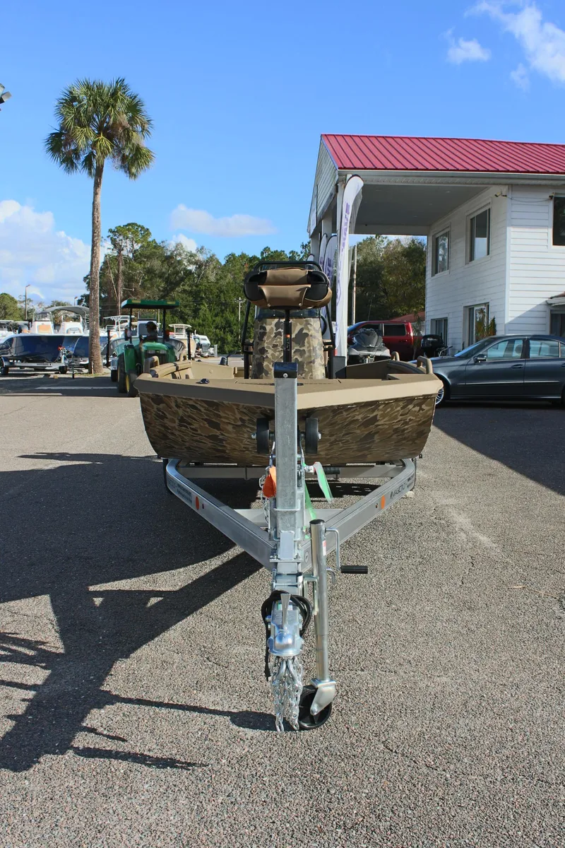 Slide: The Image of 2025 Excel 1860 F4 Shallow Water boat on trailer, outdoor dealership setting. - 2