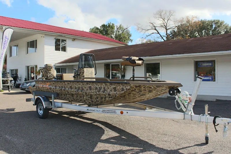Slide: The Image of 2025 Excel 1860 F4 Shallow Water boat on trailer, parked outside dealership. - 3