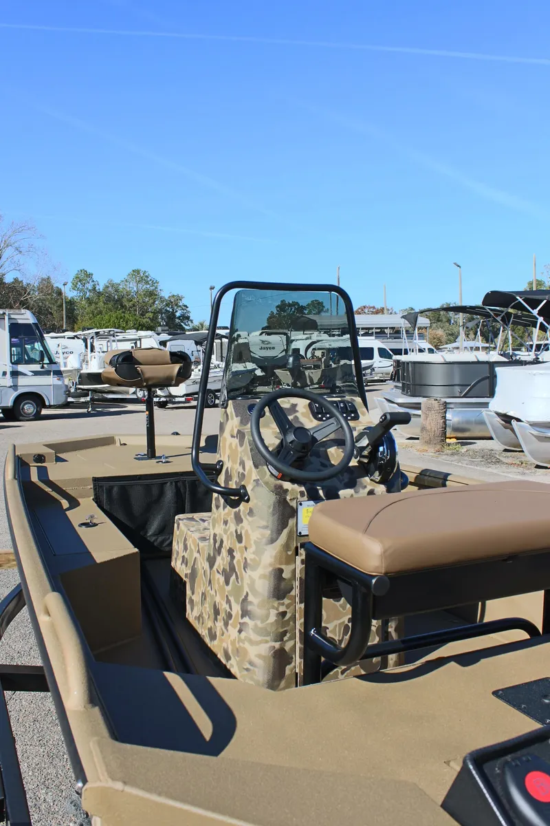 Slide: The Image of 2025 Excel 1860 F4 Shallow Water boat with camouflage design in a marina setting. - 9