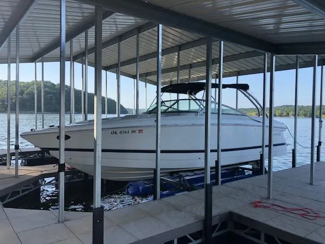 Slide: The Image of 2005 Cobalt 282 boat docked under a covered slip on a lake. - 0