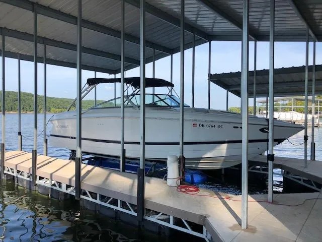 Slide: The Image of 2005 Cobalt 282 boat docked under a covered marina on a sunny day. - 1