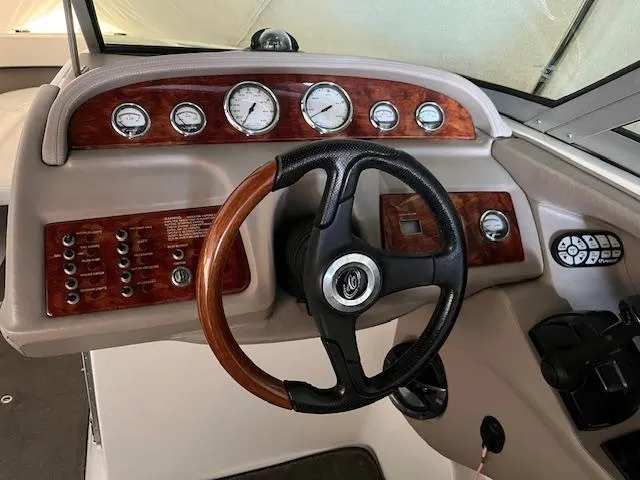 Slide: The Image of 2005 Cobalt 282 boat dashboard with wood accents and steering wheel. - 4