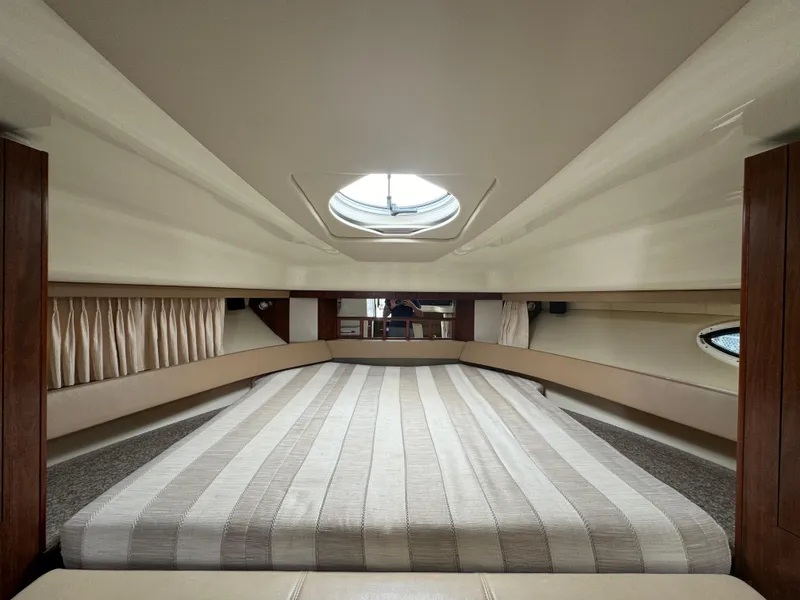 Slide: The Image of Interior cabin of 2014 Monterey 340 Sport Yacht with striped bedding and porthole. - 15