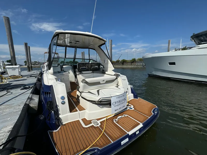 Slide: The Image of 2014 Monterey 340 Sport Yacht docked, featuring sleek design and spacious deck. - 4