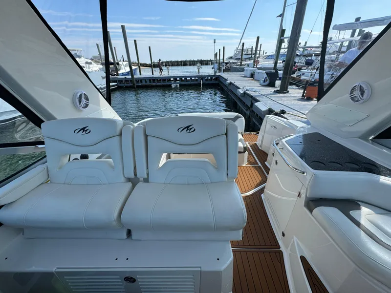 Slide: The Image of 2014 Monterey 340 Sport Yacht interior with white seating at marina. - 9