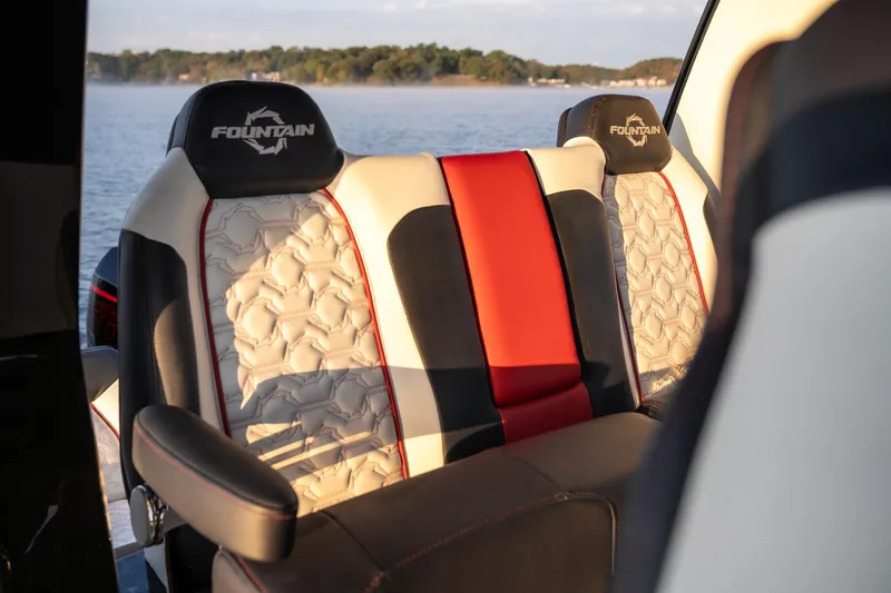 Slide: The Image of 2024 Fountain 43SCX boat seats with stylish red, black, and white design on a lake. - 14